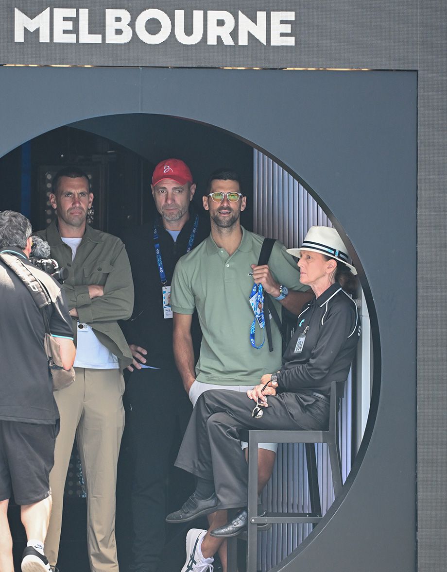 Новак Джокович (в очках) наблюдает за матчем Роджера Федерера