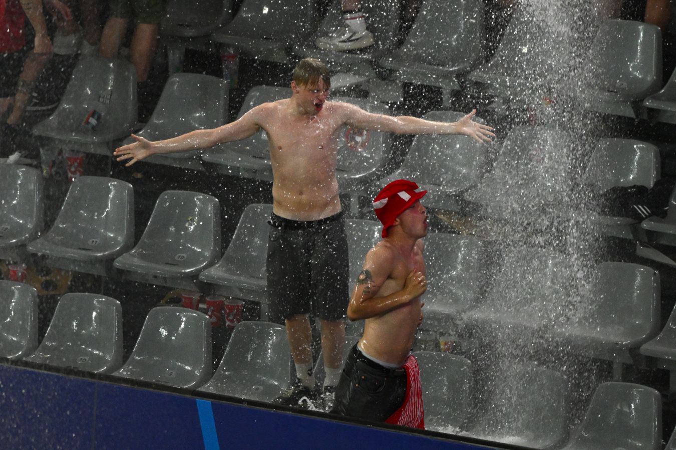 Фото: фанаты сборной Дании под потоком воды с крыши стадиона в Дортмунде