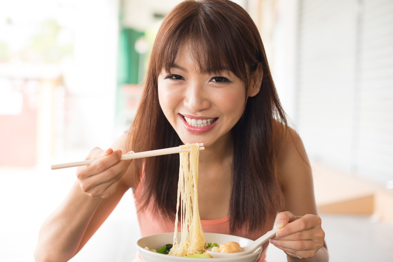 Азиатская девушка ест лапшу