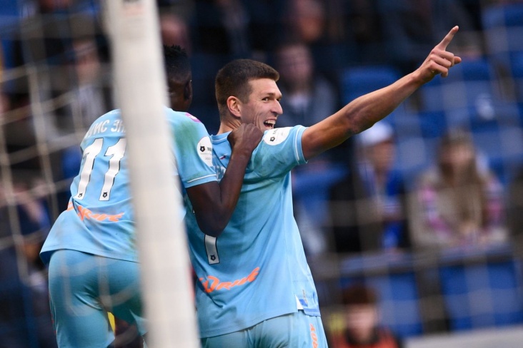 российский футболист забивает гол на стадионе